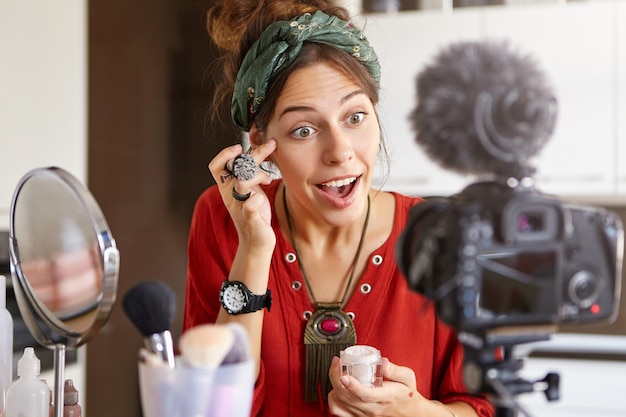Foto grátis vlogger feminina filmando vídeo de maquiagem