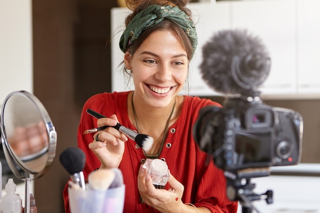 Foto grátis vlogger feminina filmando vídeo de maquiagem