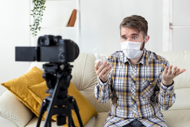 Vlogger gravando vídeo em casa com desinfetante para as mãos