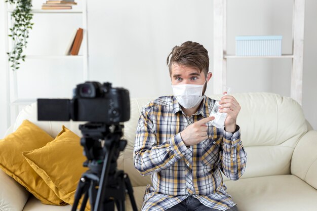 Vlogger gravando vídeo em casa com desinfetante para as mãos