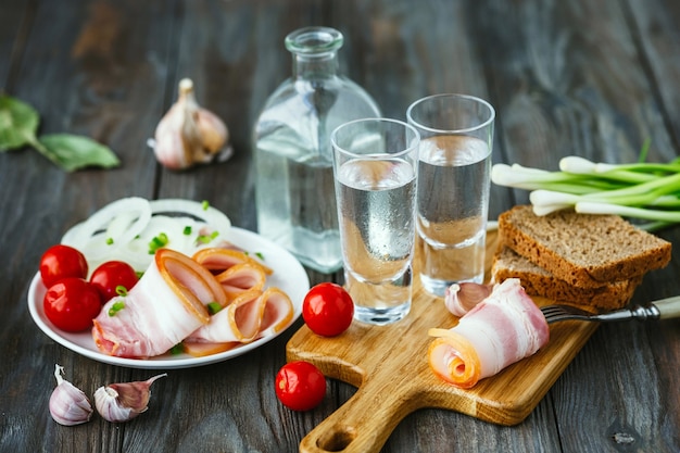 Vodka com banha e cebola verde na mesa de madeira