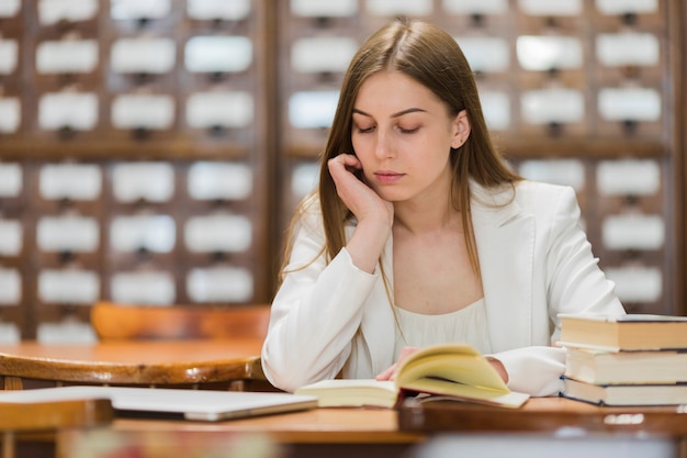 Foto grátis volta ao conceito de escola com mulher estudando na biblioteca