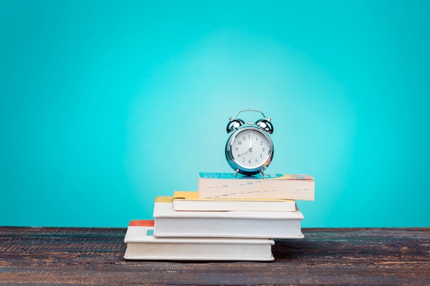 Foto grátis volta ao conceito de escola. livros, lápis de cor e relógio