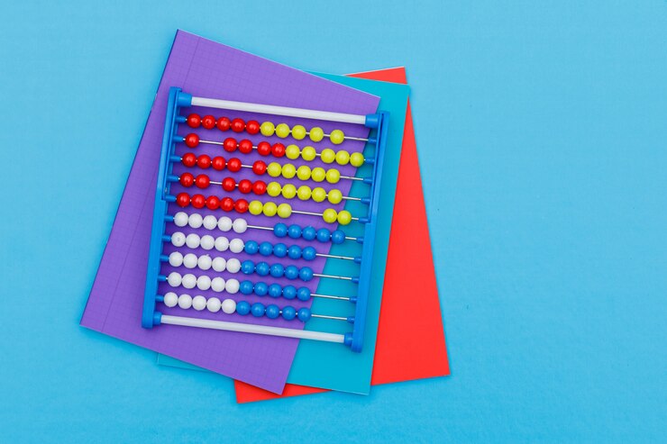 Foto grátis voltar ao conceito de escola com cadernos, ábaco na configuração plana de fundo azul.