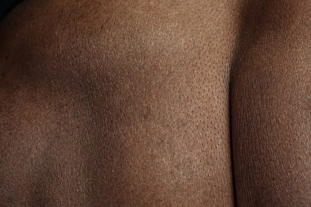 Voltar. Textura detalhada da pele humana. Close-up tiro do jovem corpo masculino afro-americano. Conceito de skincare, bodycare, saúde, higiene e medicina. Parece bonito e bem cuidado. Dermatologia.