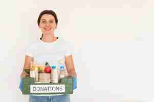 Foto grátis voluntária feminina com luvas lidando com caixa de doações de alimentos