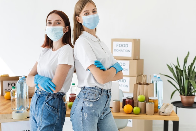 Voluntárias posando com máscaras médicas e luvas