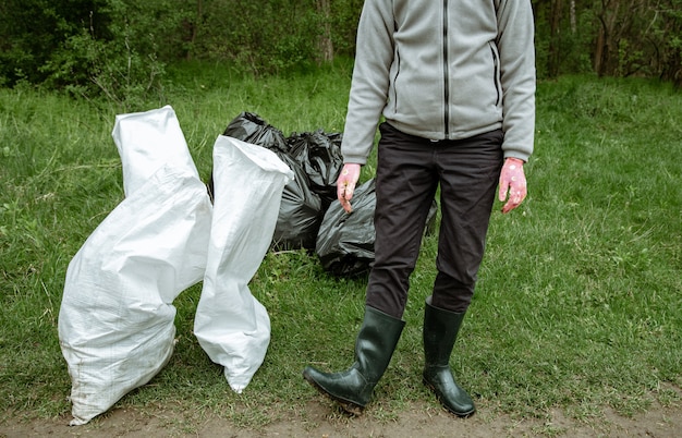 Voluntário com um saco de lixo em uma viagem à natureza, limpando o meio ambiente