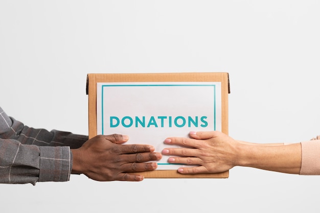 Voluntário dando uma caixa com doações para outro voluntário