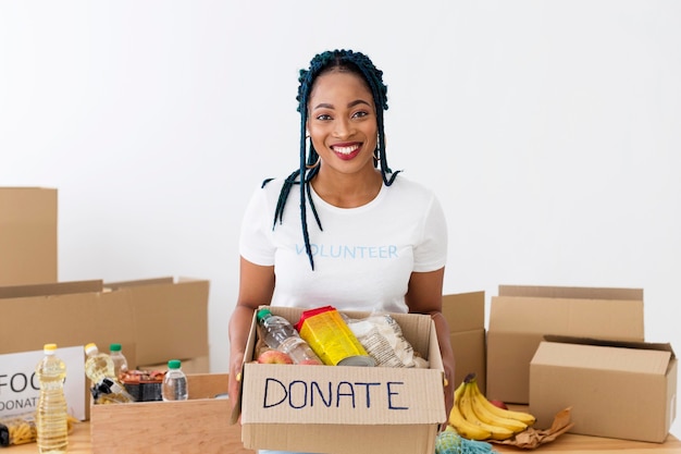 Voluntário sorridente segurando uma caixa de doações