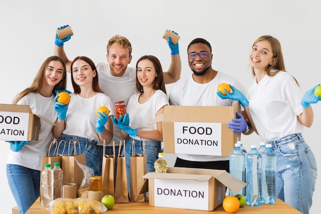 Voluntários alegres posando junto com caixas de doação