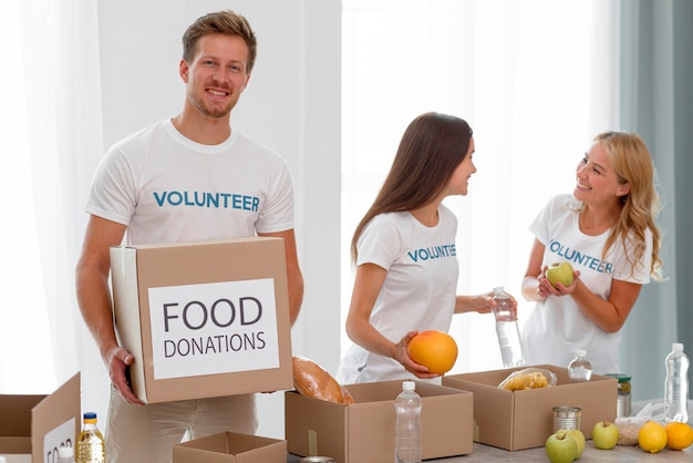 Voluntários com caixas e alimentos para caridade