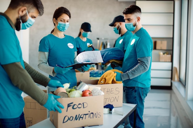 Voluntários embalando caixas de caridade com comida e roupas