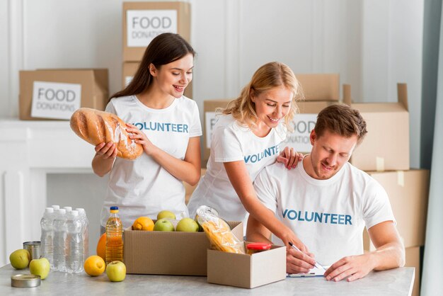 Voluntários felizes ajudando com doações de alimentos