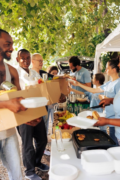 Voluntários fornecem caixas de refeições e produtos enlatados para indivíduos necessitados idosos e desabrigados recebem alimento de trabalhadores sorridentes que personificam o espírito da unidade de alimentos e organização sem fins lucrativos