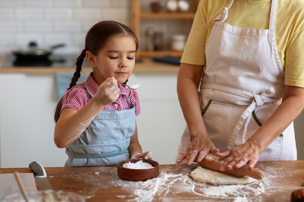 Foto grátis vovó de vista frontal e menina cozinhando juntos