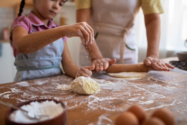 Foto grátis vovó de vista frontal e menina cozinhando juntos