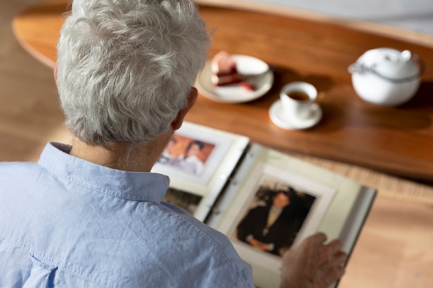 Foto grátis vovô olhando sobre álbuns de fotos