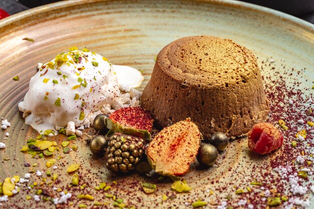 Vulcão de chocolate tingido de ouro servido com sorvete de baunilha e frutas