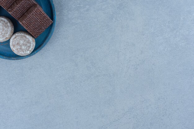 Wafers de chocolate de vista superior com cookie na placa de madeira azul.