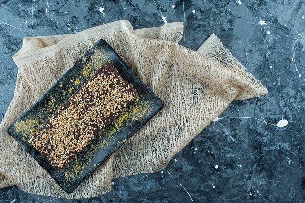 Waffle coberto de chocolate em um prato na toalha de mesa, na mesa azul.