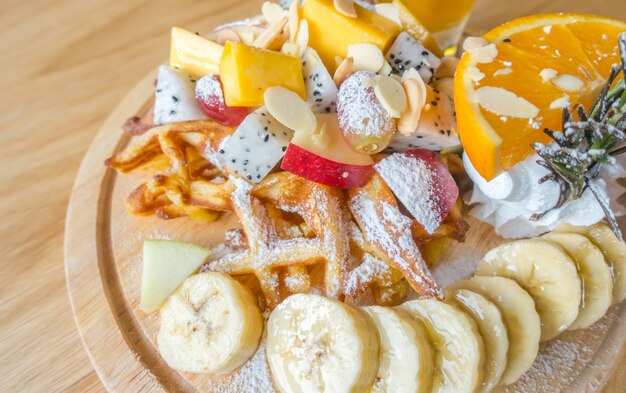 Waffle e frutas com gelado na tabela.