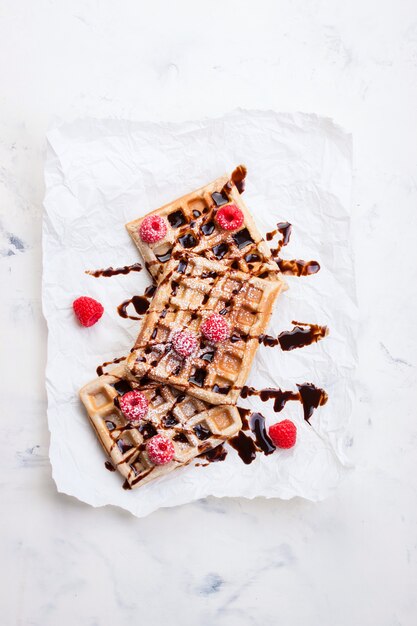 Waffles com framboesas e xarope de chocolate