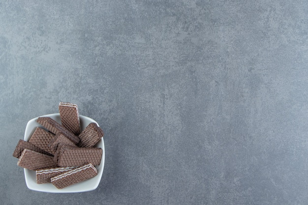 Waffles de chocolate crocantes em uma tigela branca.