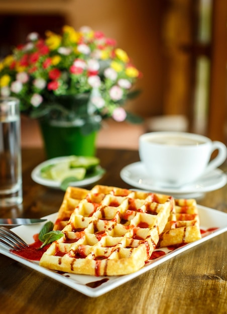 Waffles e café na mesa de madeira