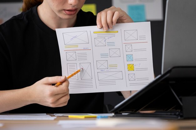 Web designer feminina com papéis e notas no escritório