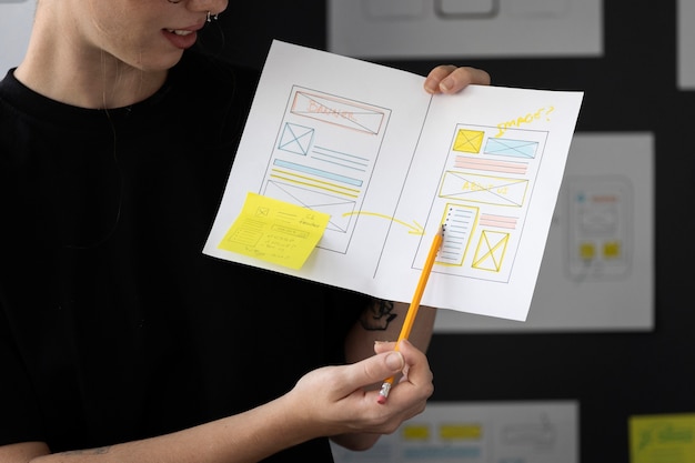 Foto grátis web designer feminina com papéis e notas no escritório