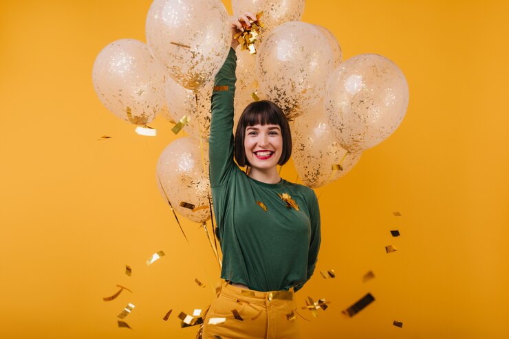 Foto grátis winsome modelo feminino relaxando em seu aniversário com um sorriso sincero. mulher incrível com cabelo preto relaxante depois da festa.