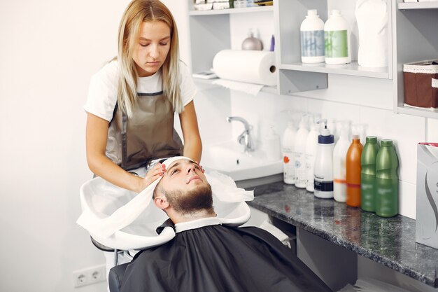 Woma lavando a cabeça do homem em uma barbearia