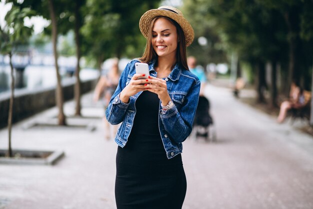 Womanwearing, vestido, e, chapéu, exterior, parque, com, telefone