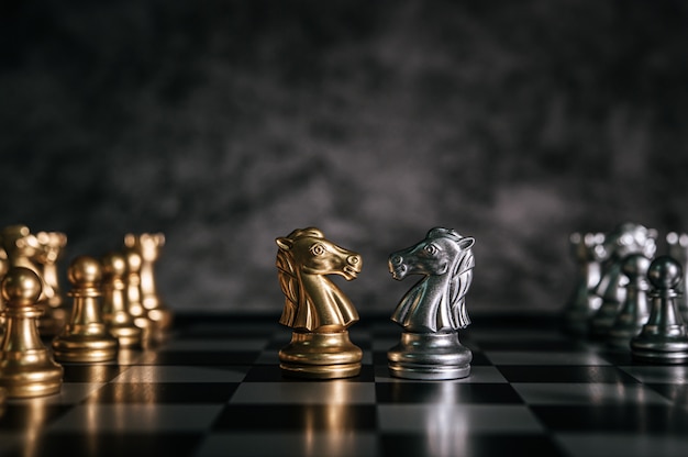 Xadrez de ouro e prata no jogo de tabuleiro de xadrez para o conceito de liderança de metáfora de negócios