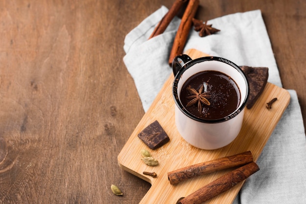 Xícara de ângulo alto com chocolate quente e canela