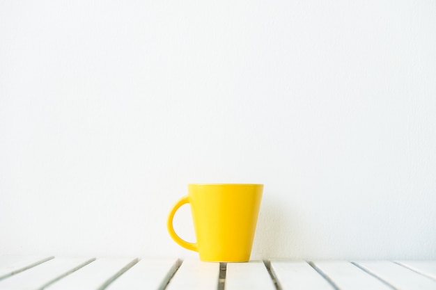 Foto grátis xícara de café amarelo na mesa