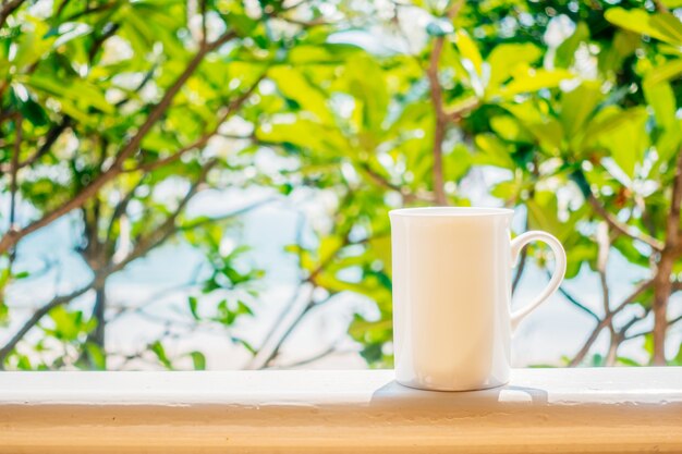 Xícara de café branca com vista para o exterior