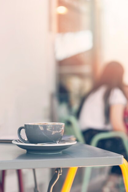 Xícara de café cinza na mesa no café