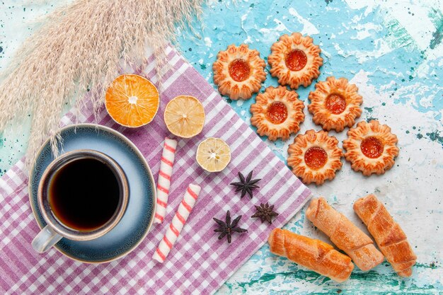 Xícara de café com bagels e biscoitos no bolo de fundo azul claro com vista de cima