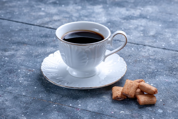 Xícara de café com biscoitos em formato de travesseiro em uma mesa iluminada, biscoito de café massa doce