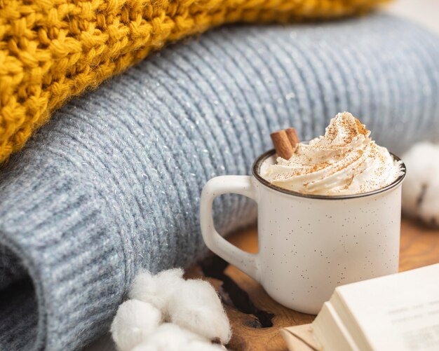 Xícara de café com chantilly e suéteres