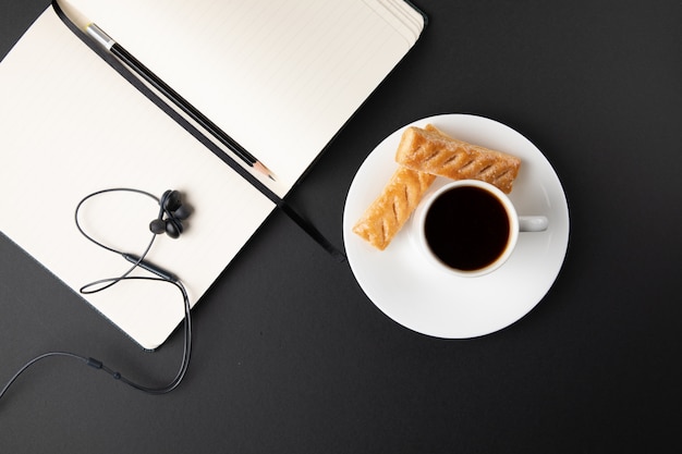 Xícara de café com doces e laptop