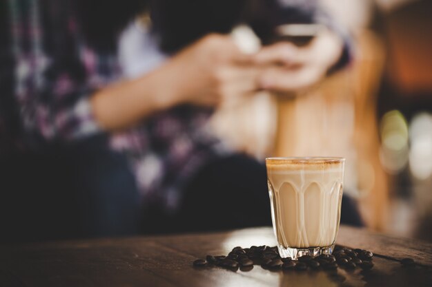 Xícara de café com leite na mesa de madeira no café café