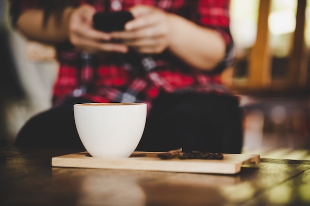 Xícara de café com leite na mesa de madeira no café café