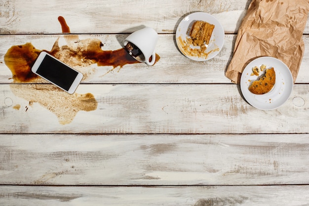 Xícara de café derramado na mesa de madeira