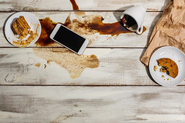 Xícara de café derramado na mesa de madeira