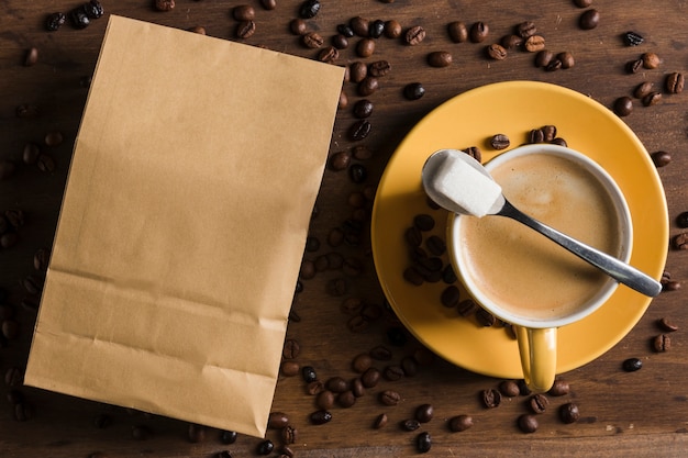 Xícara de café e açúcar perto de pacote