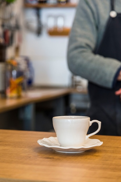 Foto grátis xícara de café e pires de cerâmica no balcão de bar café