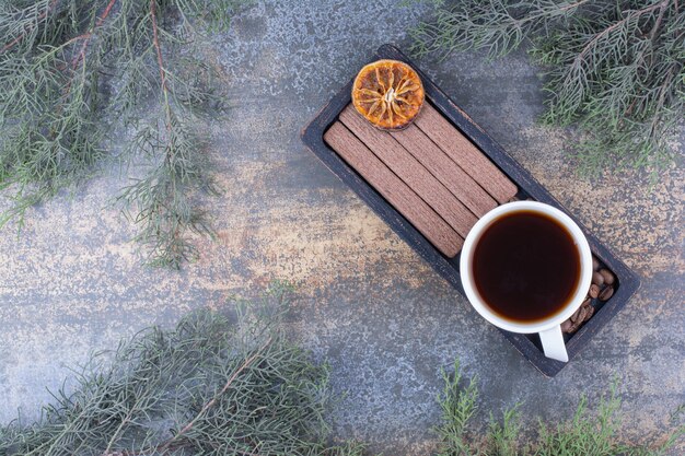 Xícara de café expresso, biscoitos e grãos de café na chapa preta. foto de alta qualidade